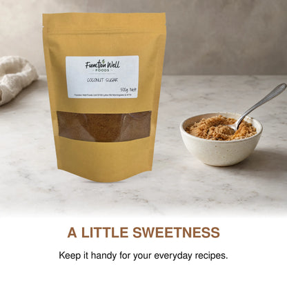 Function Well Foods Organic Coconut Sugar 500g packaging on a kitchen bench beside a small dish of organic coconut sugar.