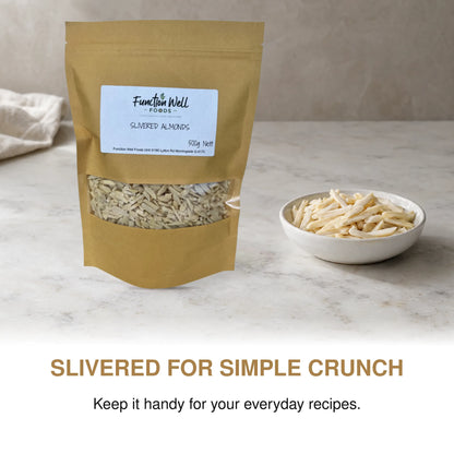 Function Well Foods Slivered Almonds 500g packaging on a kitchen bench beside a small dish of blanched slivered almonds.