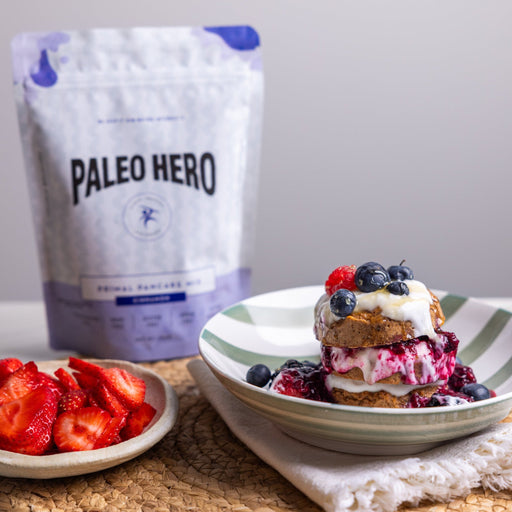 Strawberries, a dessert with whipped cream and berries, and a bag of Paleo Hero  Pancake Mix