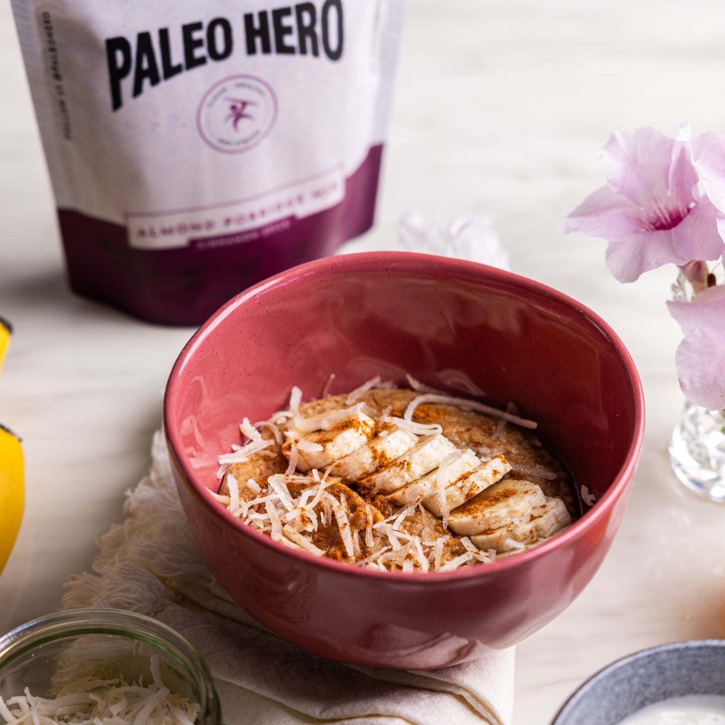 Bowl of cereal with bananas, yogurt, and a jar of honey on a table